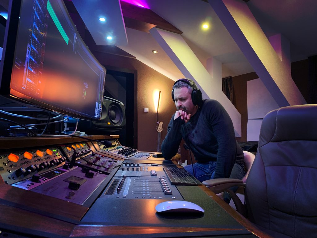 Zvukový inžinier sústredene pracuje pri mixážnom pulte v štúdiu Apollo
